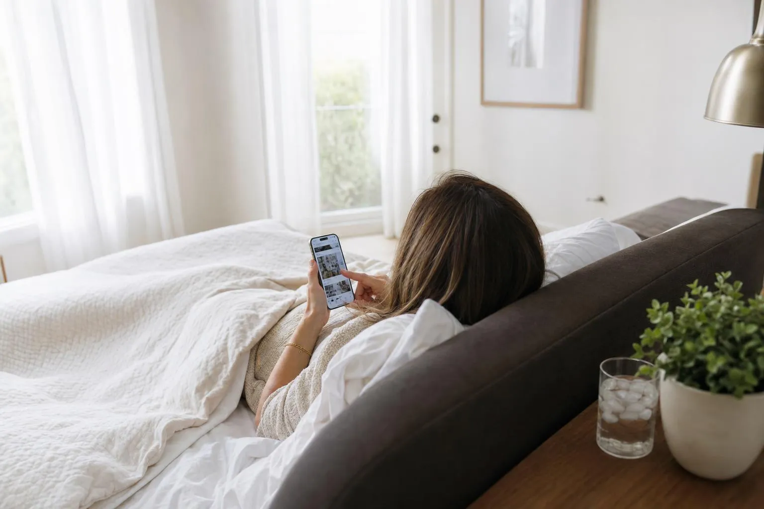 Person resting with head elevated on layered pillows in a calm, softly lit bedroom